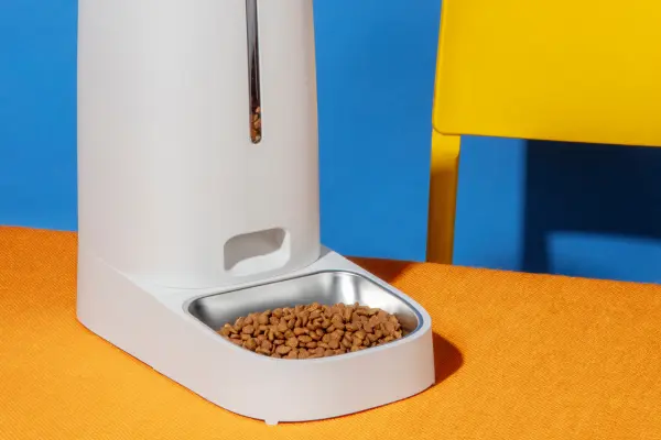 Alimentador automático branco com ração seca para cães e gatos.